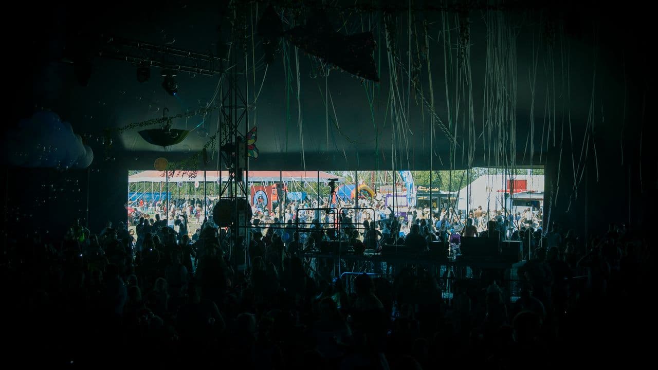 Foule de spectateurs devant une scène de concert éclairée par des projecteurs.