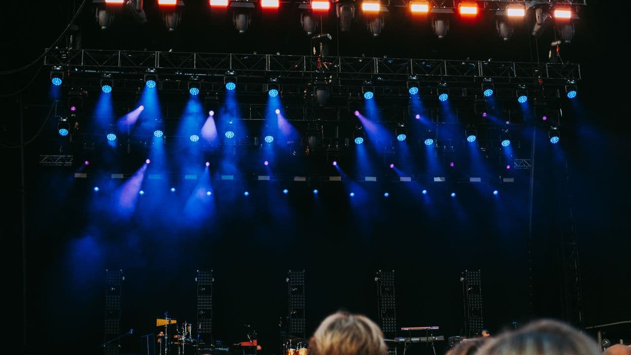 Foule dense lors d’un concert, éclairée en contre-jour.