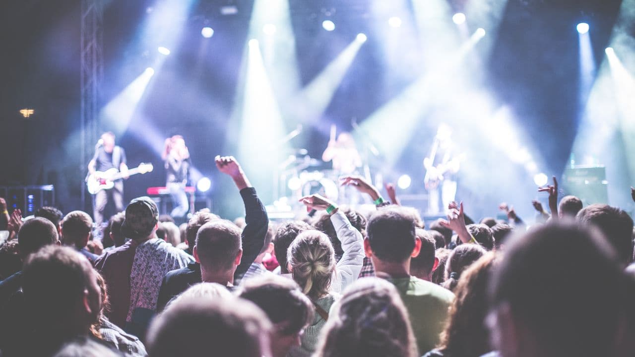Public d’un festival de musique sous un ciel de fin de journée.