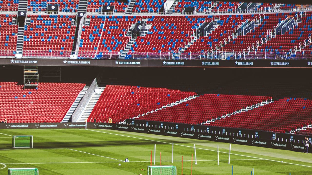 Gradins d’un stade et pelouse éclairée par les projecteurs.